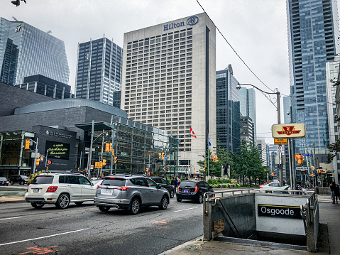 Toronto, ON, Canada - 10 05 2018: in front of Osgoode subway station, the view to the street and buildings in Toronto downtown, under cloudy sky.