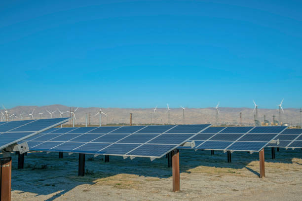 istock Solar panels and windmills with blue sky and mountain in the background 1446613744