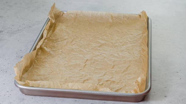 istock Baking pan with parchment paper close-up on the kitchen table 1446613883