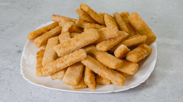 istock Frozen breaded fish sticks close-up on a plate 1446613895