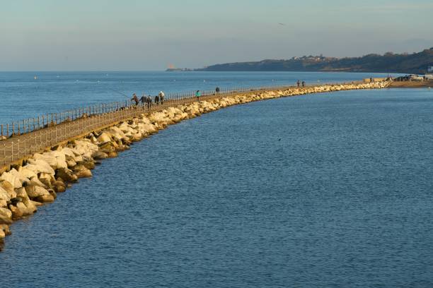 schöne aussicht auf den wellenbrecher in der herne bay, genannt neptuns arm - herne stock-fotos und bilder