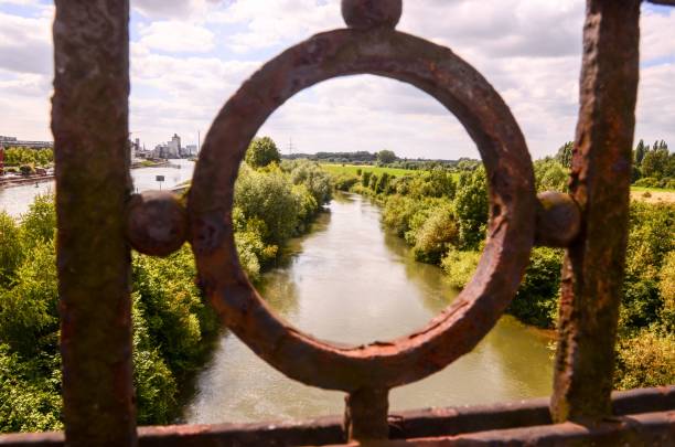 istock Green river bridge view through rusty railings on a sunny summer day 1446617229