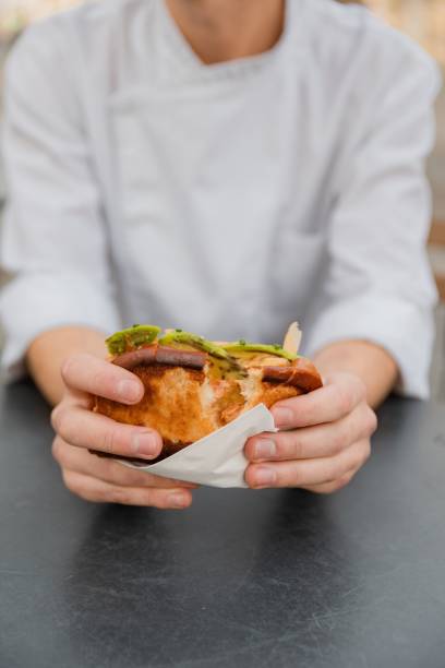 istock Vertical high-angle shot of hands splitting the stuffed crunchy fresh bread 1446617649