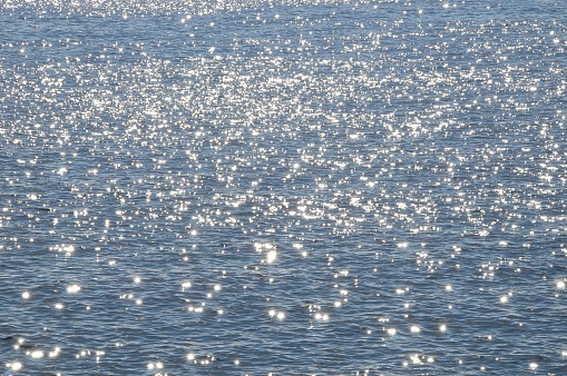 Vast ocean speckled with sunlight, 16x9
