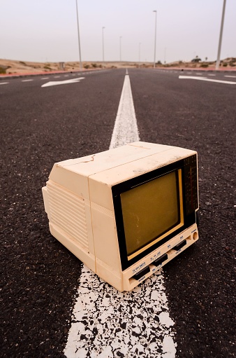 A Broken Gray Television Abandoned on the Road