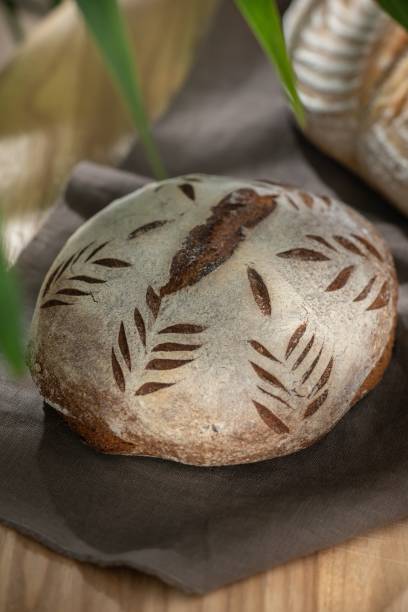 istock Vertical shot of freshly baked organic wheat bread, sourdough bread with leaf patterns 1446618579