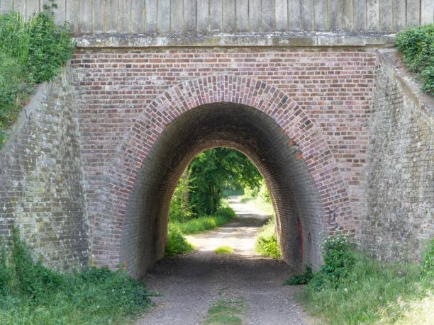 istock Medieval brick tunnel over a footpath under the bright sunlight 1446619144
