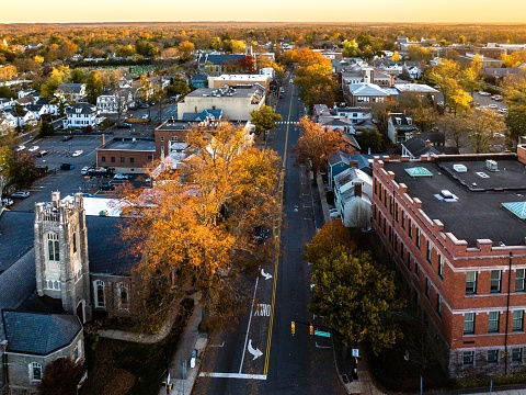 A drone view of golden sunrise over Princeton New Jersey. Cityscape with famous landmarks, university, residential buildings and roads.