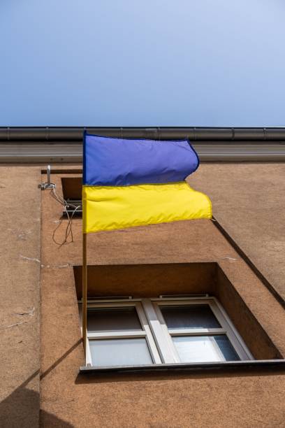 istock Ukraine national flag hung in front of a white window under a clear sky 1446620721