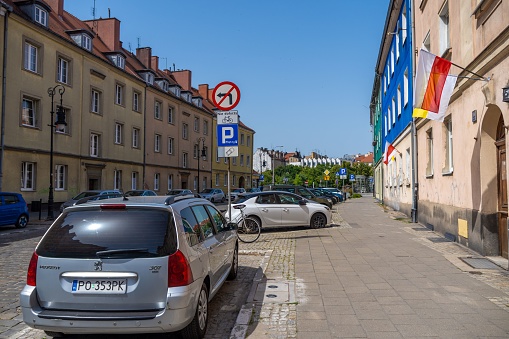 Poznan, Poland – June 19, 2022: An old building with Polish flag and parked car on the Chwaliszewo street