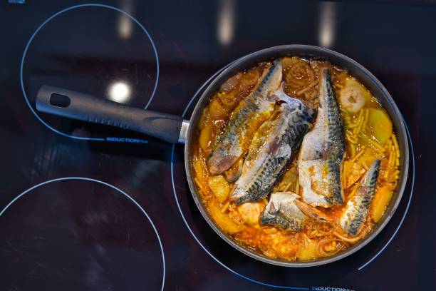 istock Top view of a fish dish in a cooking pan placed on a stove 1446621904