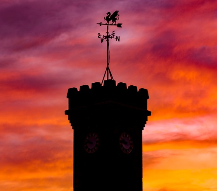 A silhouette of a dragon weather vane of Penrhiwceiber war memorial,Mountain Ash,South Wales at sunset