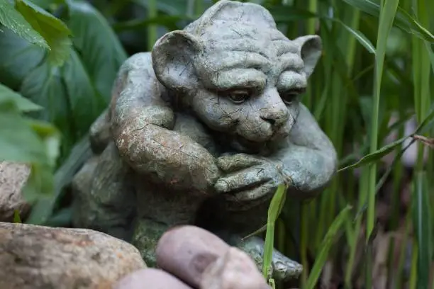 A statue of a goblin in a garden