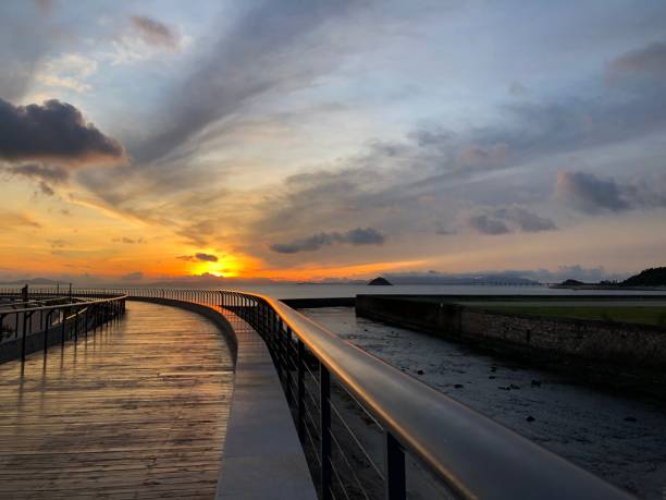 istock Coastal landscape with a pier under a cloudy sunset sky 1446624448