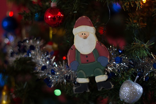 A closeup of cute toys and garlands on the Christmas tree with a blurry background