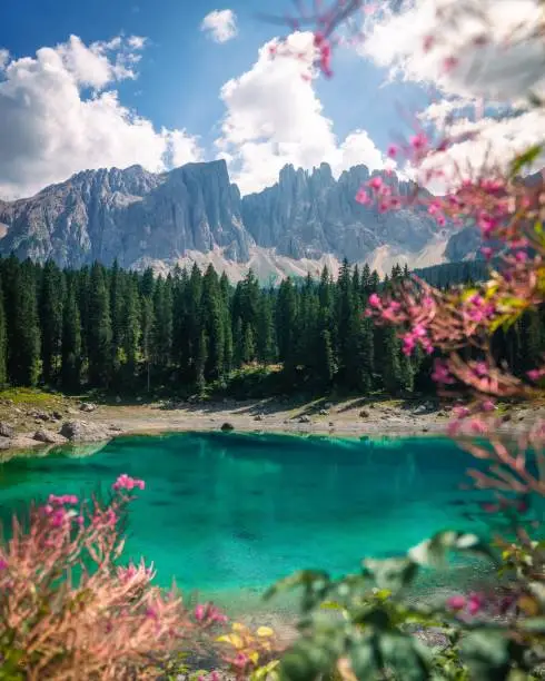 The scenic alpine lake Carezza against the alpine mountains Dolomites in South Tyrol, Italy
