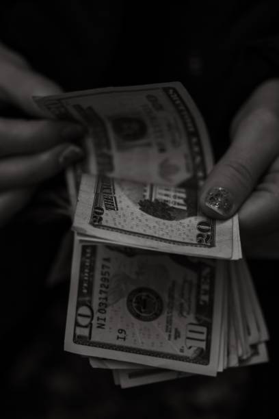 istock Vertical grayscale of a female hand counting dollar bills 1446627693