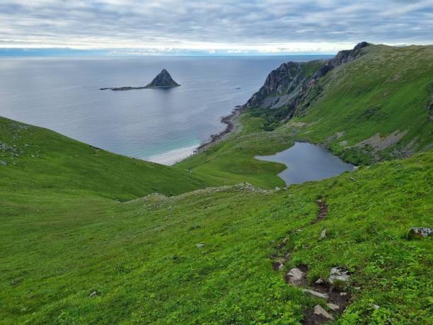 istock Cloudy sky over the lake surrounded with green hills in Norway in spring 1446627718