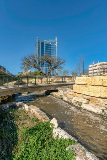 istock River flowing under a bridge with trees buildings and blue sky background 1446627749