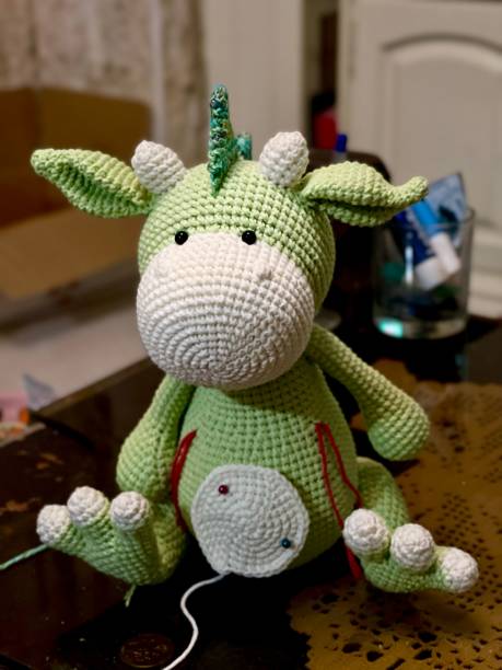 istock Green knitted doll on a table waiting to be completed 1446629192