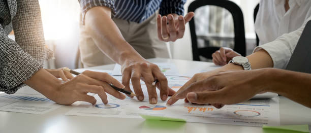 Businesspeople analyzing investment graph meeting brainstorming and discussing plan in meeting room, investment concept
