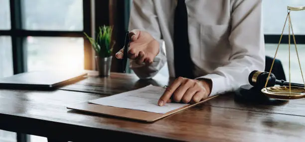 Photo of Close up business lawyer man reaching out sheet with contract agreement proposing to sign.Full and accurate details, individual who owns the business sign personally,director of the company, solicitor.