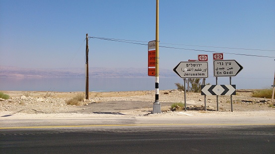Tourist standing next to informational sign in barren landscape