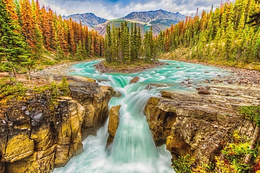 A breathtaking view of amazing Sunwapta Falls Waterfall in Canada with silk effect water and colorful trees