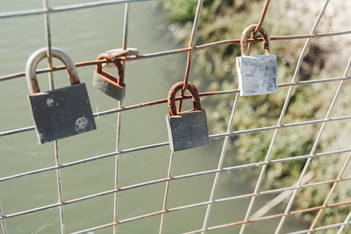 A closeup shot of rusty padlocks hanging on a bridge