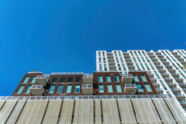 istock Looking up at modern luxury apartment against vibrant cloudless blue sky 1446636897