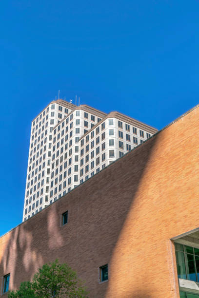 istock Building exterior with brick wall and white wall against blue sky on a sunny day 1446637249