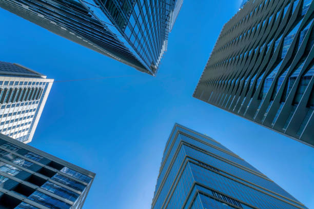 istock Looking up at the cloudless blue sky with towering skyscrapers apartments 1446638251