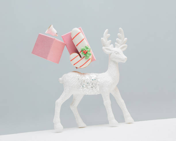 istock White cute reindeer, candy cane cookie, bell and pink gift boxes on isolated gray background with copy space. New Year holiday decoration concept. Christmas symbol. Minimal abstract Xmas gift card. 1446638893