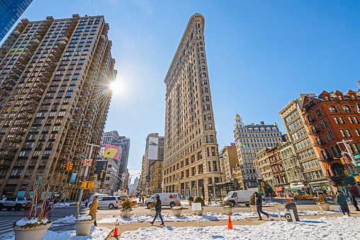 New York City, USA - Wide angle view of Flatiron Building in Midtown district, Pedestrians walking on the street, New York, USA