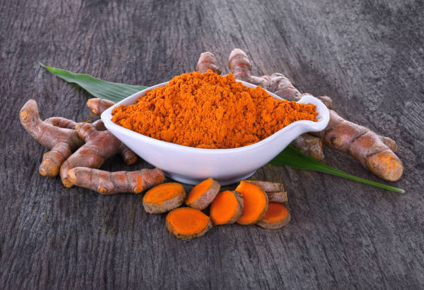 istock fresh tumeric and tumeric powder (curcumin, Curcuma longa Linn) isolated on wooden background 1446645534