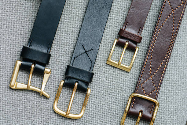 istock Classical faux leather belts lined up next to each other on gray fabric surface. 1446650355