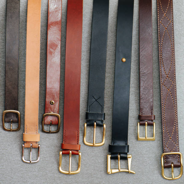 istock A number of classical faux leather belts lined up on a gray fabric surface. 1446650361