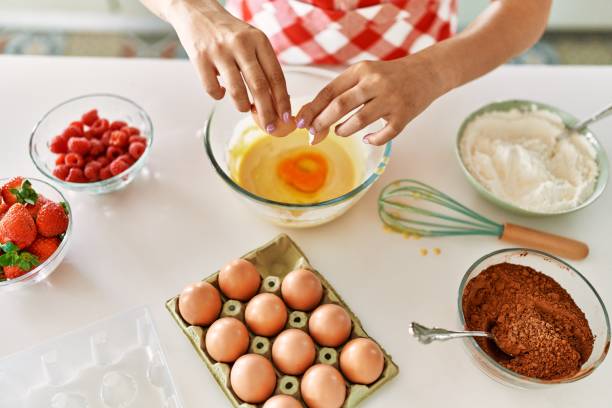 istock Young beautiful hispanic woman pouring egg on bowl at the kitchen 1446652933