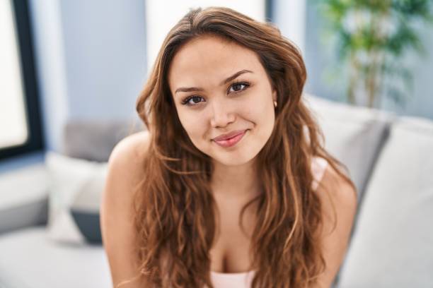 istock Young beautiful hispanic woman smiling confident sitting on sofa at home 1446653049