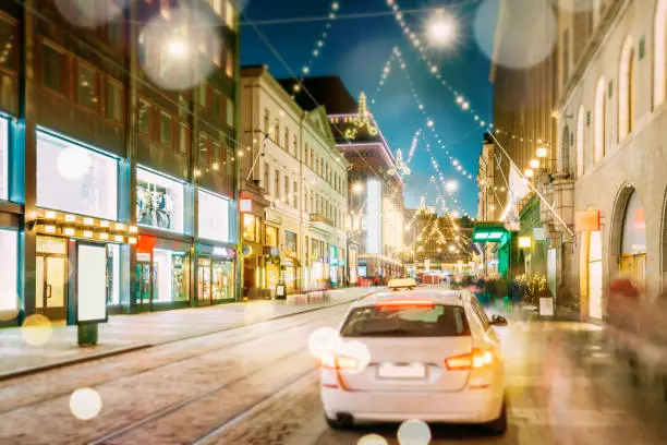 Photo of Helsinki, Finland. Taxi Car Parking On Aleksanterinkatu Street. Effect Bokeh Xmas Christmas Lights Decorations And Festive Illumination. Winter Christmas Xmas Holiday Season. Boke View