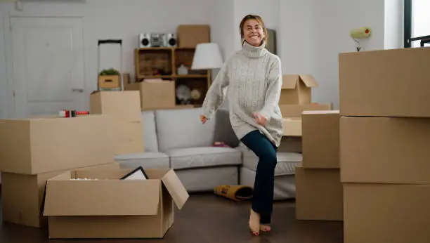 Middle age hispanic woman smiling confident dancing at new home