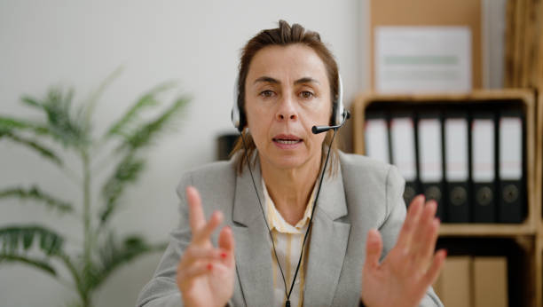 istock Middle age hispanic woman call center agent having conversation at office 1446654689