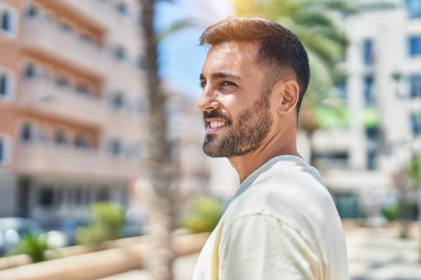 Young hispanic man smiling confident looking to the side at park