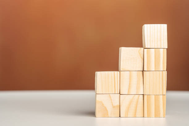 istock Side view of stacked blank wooden blocks on a white table with a brown background 1446669735