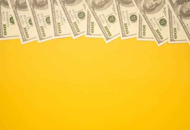 istock Top view of US dollar banknotes on a yellow background 1446670144