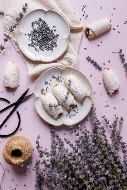 talerz jabłkowych ciasteczek między wiązką lawendy, czarnymi nożyczkami i sznurkiem na liliowym tle - sugar flowers zdjęcia i obrazy z banku zdjęć