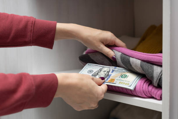 istock man hides money on a shelf with things. 1446672756