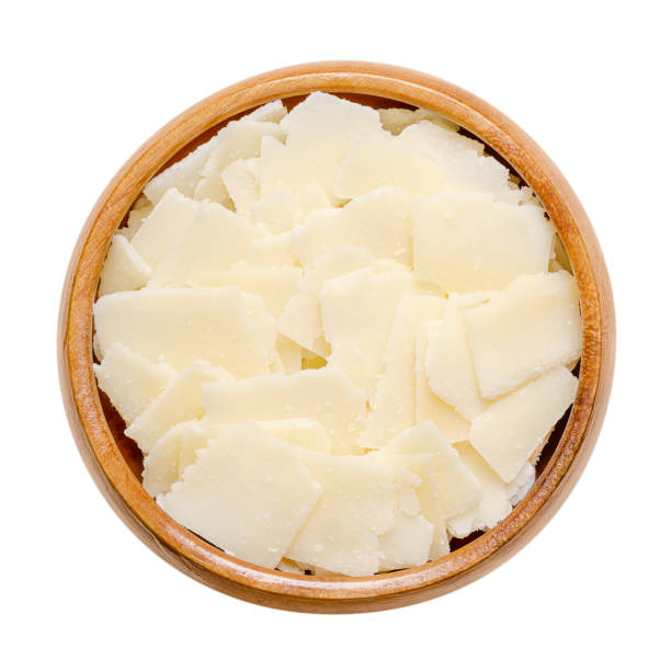Grana Padano cheese flakes, Italian hard cheese, in a wooden bowl Grana Padano cheese flakes, in a wooden bowl. Italian hard cheese, similar to Parmesan, crumbly-textured, with strong savory flavor and slightly gritty texture, made from unpasteurized cow milk. Photo grana padano stock pictures, royalty-free photos & images