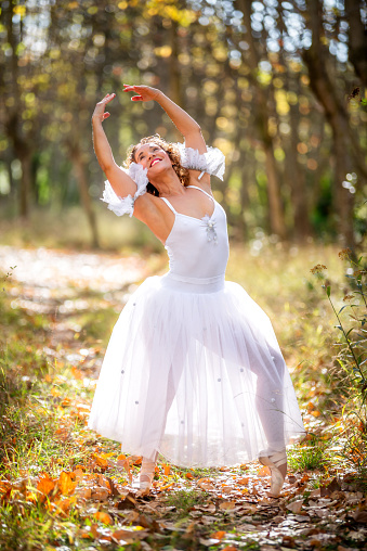 Ballerina ballet woman stretching posing exercising at nature park