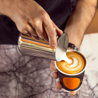 Male barista making coffee. Making latte art close up